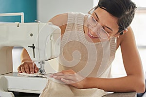 Smile, woman and sewing machine in apartment for small business, fashion design and pride. Female seamstress, creativity