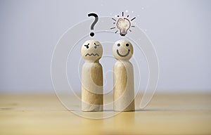 Smile wooden figure with glowing lightbulb and sad wooden figure with question mark for creative thinking idea can solving