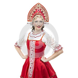 Smile young woman hands on hips portrait in russian traditional costume -- red sarafan and kokoshnik.