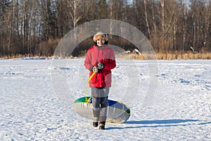 Smile young woman with snow tubing winter activity, runs in winter. Winter entertainment