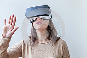 Smile young woman wearing using virtual reality VR glasses helmet headset on white background. Smartphone using with