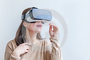 Smile young woman wearing using virtual reality VR glasses helmet headset on white background. Smartphone using with virtual