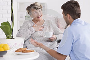 Smiled elder woman and her young male nurse