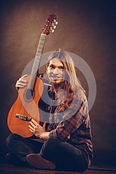 Smiled guitarist with his instrument.