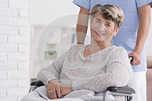 Smiled senior woman with her caregiver
