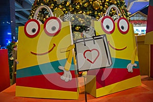 Smiley animated shopping bags with christmas tree in the background.