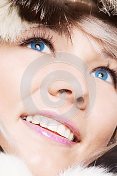 Smiley blond with blue eyes in furs