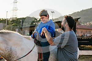 Smiley boy with cerebral palsy receiving equine therapy