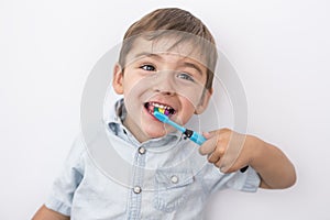Smiley boy cleans a teeth isolated on grey background
