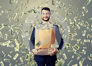Smiley businessman holding paper bag with money