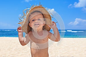 Smiley child with hat has fun on sea sand beach