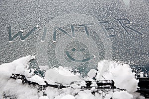 Smiley drawn on snowy windshield