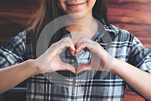 Asian woman making heart hand sign with feeling inlove