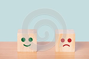 Smiley face and blurred sad face icon on wood cube, Customer