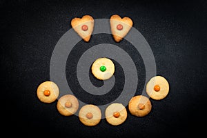 Smiley face of childish cookies on black background