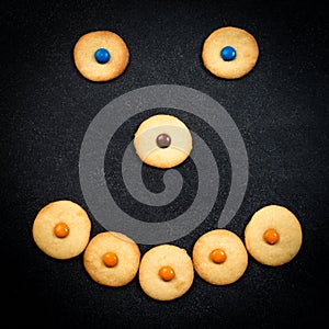 Smiley face of childish cookies on black background
