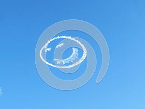 Smiley face clouds in blue sky