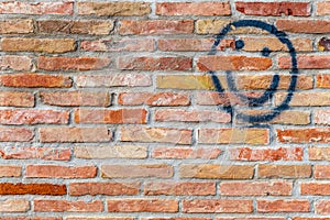 Smiley face drawn on a brick wall