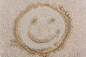 Smiley face drawn in the sand from above
