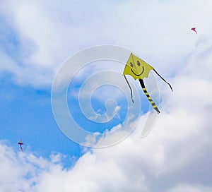 Smiley Face Kite Flying in a Cloudy Skiy