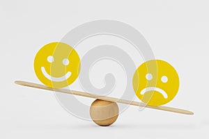Smiley face and sad face on scale - Concept of sadness as predominant emotion
