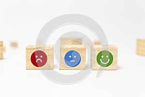 smiley face on wood block cube - business services rating customer experience, Satisfaction survey concept - Feedback