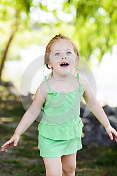 Smiley little girl having fun with bubble blower