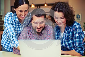 Smiley man and women working with laptop