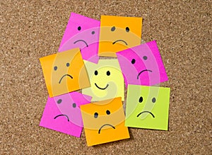 Smiley post it note on corkboard in happiness versus depression concept