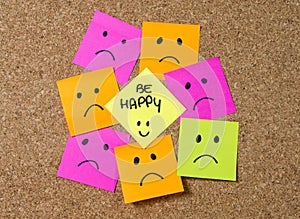 Smiley post it note on corkboard in happiness versus depression concept