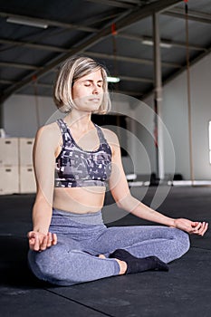 Smiley relaxed mid adult woman resting meditating in easy pose with eyes closed in her yoga practice