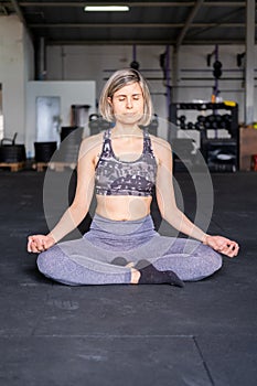 Smiley relaxed mid adult woman resting meditating in easy pose with eyes closed in her yoga session