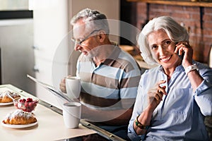 Smiley retired couple having morning coffee in the kitchen