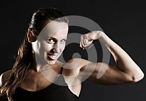 Smiley sportswoman showing her muscles