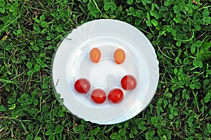 Smiley from tomato on a white plate.