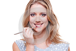 Smiley woman applying lipstick