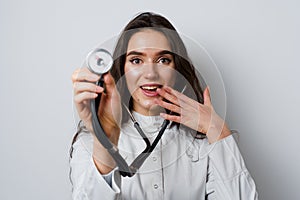 Smiley woman doctor surgeon with stethoscope on white background. Professional medecine. advert for medical clinic.