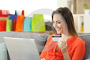 Smiley woman paying on line with credit card