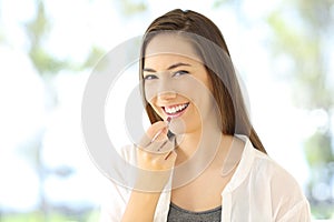 Smiley woman taking a pill looking at you
