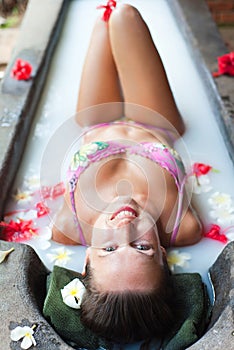 Smiley woman taking pleasure in milk bath