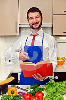 Smiley young man pointing at the cookbook