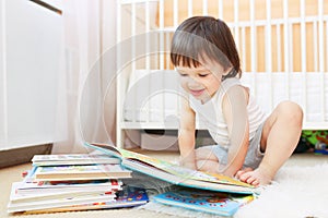 Smiling 2 years toddler reading books