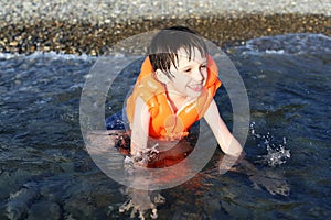 Smiling 5 years boy swimming in the sea