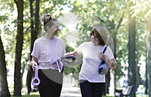 Smiling active senior women walking after sports, doing fitness in the park