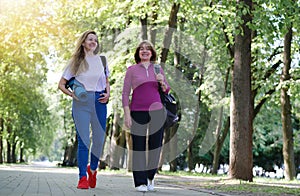Smiling active senior women walking after sports, doing fitness in the park