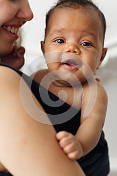 Smiling adorable baby with happy mother in sling