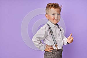 Smiling adorable child boy shows thumbs up