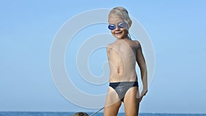 Smiling adorable child enjoying blue sea surfboarding bodyboard. Slow motion