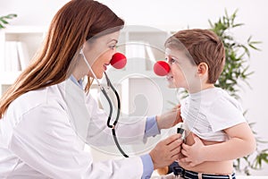 Smiling adorable female doctor clown listen patient heart