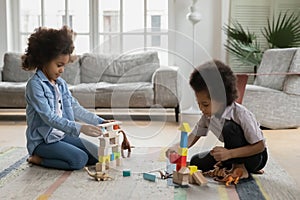 Smiling adorable mixed race small children siblings playing toys.